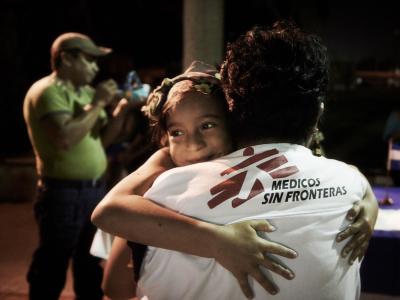 MSF social worker hugs a migrant girl