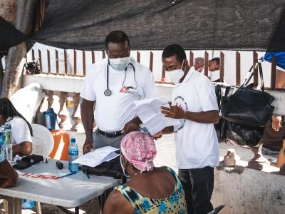 MSF Medical Doctor, Mayard Mitial (R), and MSF Medical Doctor, Fenelon Jean (L), consult with a patient in St Yves.