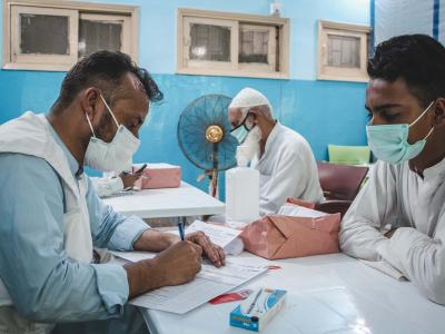 An MSF doctor taking the medical history of someone coming for their COVID-19 vaccination. They check if he has any symptoms of COVID, or is currently taking any medication. 
