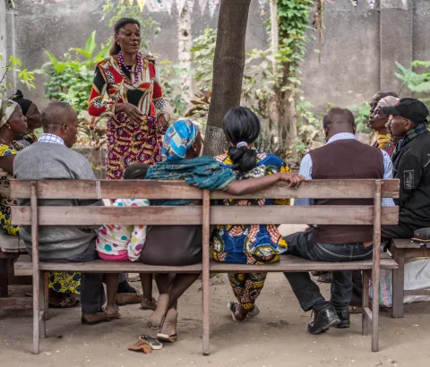 A member of network of people living with HIV sentizes HIV patients during a community ART distribution meeting.