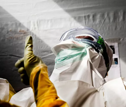 Nurses check each other's PPE as the prepare to enter the high-risk zone in MSF's Ebola treatment center in Sierra Leone.