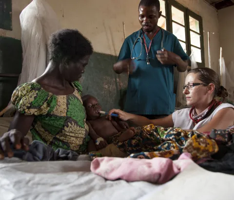 Sophie Allot, a MSF nurse, gives therapeutic milk to a child affected by measles and malnutrition inside the intensive care unit of the Titulé hospital. Malnutrition is a medical complication often associated with measles.