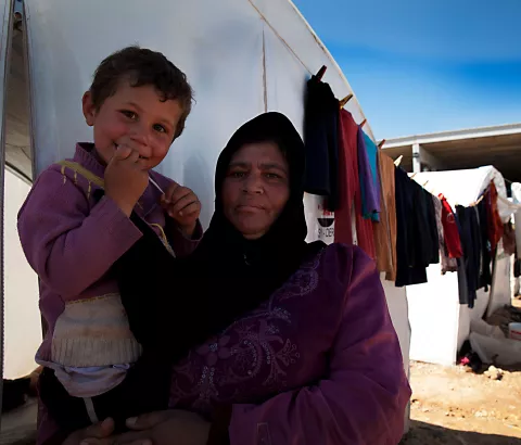 A Syrian displaced woman, Saleha Mustafa, and her young child in a transit camp next to the Turkish border.