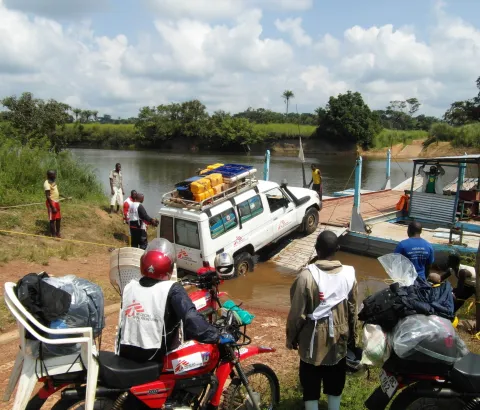 MSF mobile medical team crosses the river with cars and motorbikes to reach remote villages. 