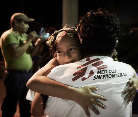 MSF social worker hugs a migrant girl