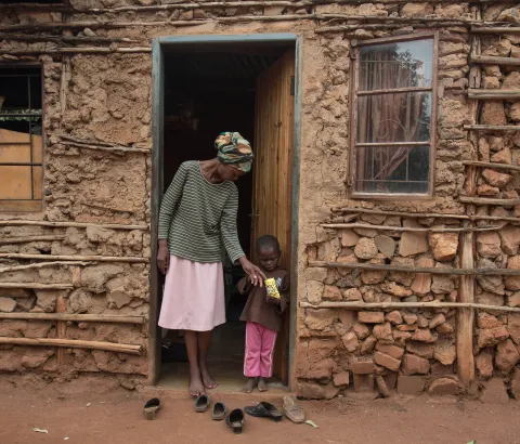Winile stands outside her house in the Manzini region of Swaziland