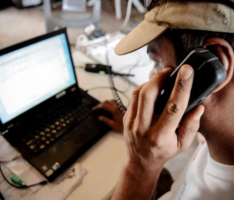 MSF employee using a phone and laptop