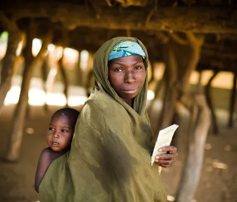 A woman who took her child to get vaccinated against meningitis holds the child's vaccination card at a vaccination site in Safa Dougoumi, Niger on Monday April 20, 2009.