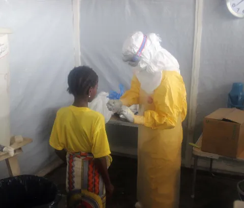 A nurse gives pain killers to a 12-years old girl staying in the Ebola isolation ward.