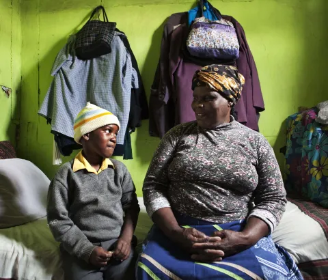 Thenjiwe Madzinga, 66, sits on with her grandson Thina Gxotelwa in the small room they share in a shack in Cape Town's Khayelitsha township, February 23, 2010. Madzinga cares for her five grandchildren, including four who were orphaned when Madzinga's own daughter died from AIDS in 2002. Some 5.5 million people live with HIV/AIDS in South Africa - more than in any other country - placing a heavy burden on a society still struggling with the legacy of Apartheid. 