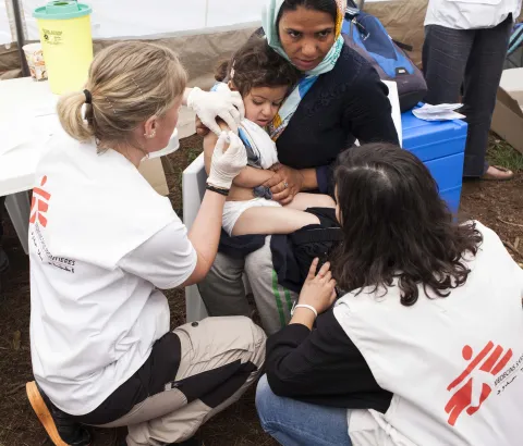 Egima from Afghanistan has her daughter Satayesh vaccinated by an MSF team. A Medecins Sans Frontieres (MSF) team vaccinate children at Idomeni camp in Northern Greece. With the aim of protecting them against the most common preventable diseases linked with the substandard living conditions in which they are forced to live. Photograph by Rocco Rorandelli