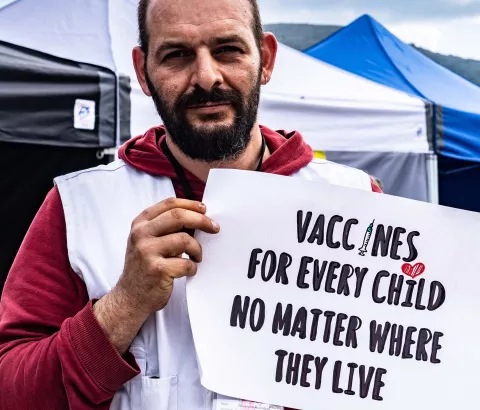 •	MSF logistician, Athanasios Papadopoulos holding a sign advocating for broader use of the pneumonia vaccine at a lower price