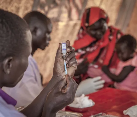 Health worker prepares PCV for a child during an MSF vaccination campaign in Yida refugee camp, South Sudan, July 2013.