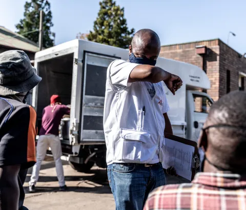 An MSF Health Promoter speaks with people about how to keep safe during the COVID-19 pandemic.