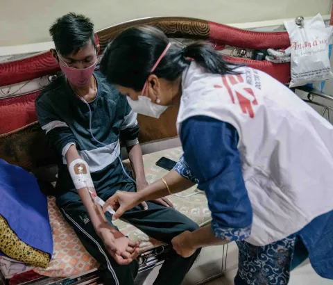 Prachi, an MSF nurse, performs a pre-infusion procedure for Chetan, who lives with DR-TB.
