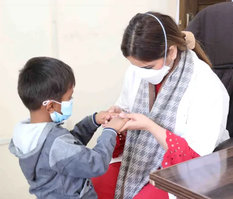 MSF doctor Dr. Maham Khalid is examining four-year-old Ahmad during a consultation at the MSF-supported Programmatic Management of Drug-Resistant Tuberculosis (PMDT) site in Gujranwala, Punjab.