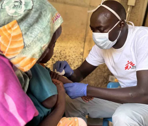 Salah Aldeen - nurse – places an intravenous line to Marwa, 3 years. Marwa was admitted the day before, as she was presenting common symptoms of measles. Amir, her big brother, who lies in the next tent, was admitted 5 days earlier for the same reason.